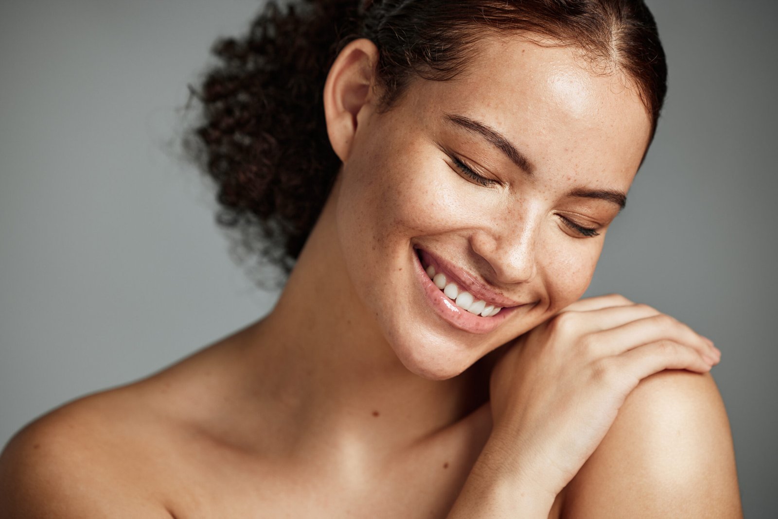 Mulher com pele natural em estúdio, representando cuidado e saúde da pele